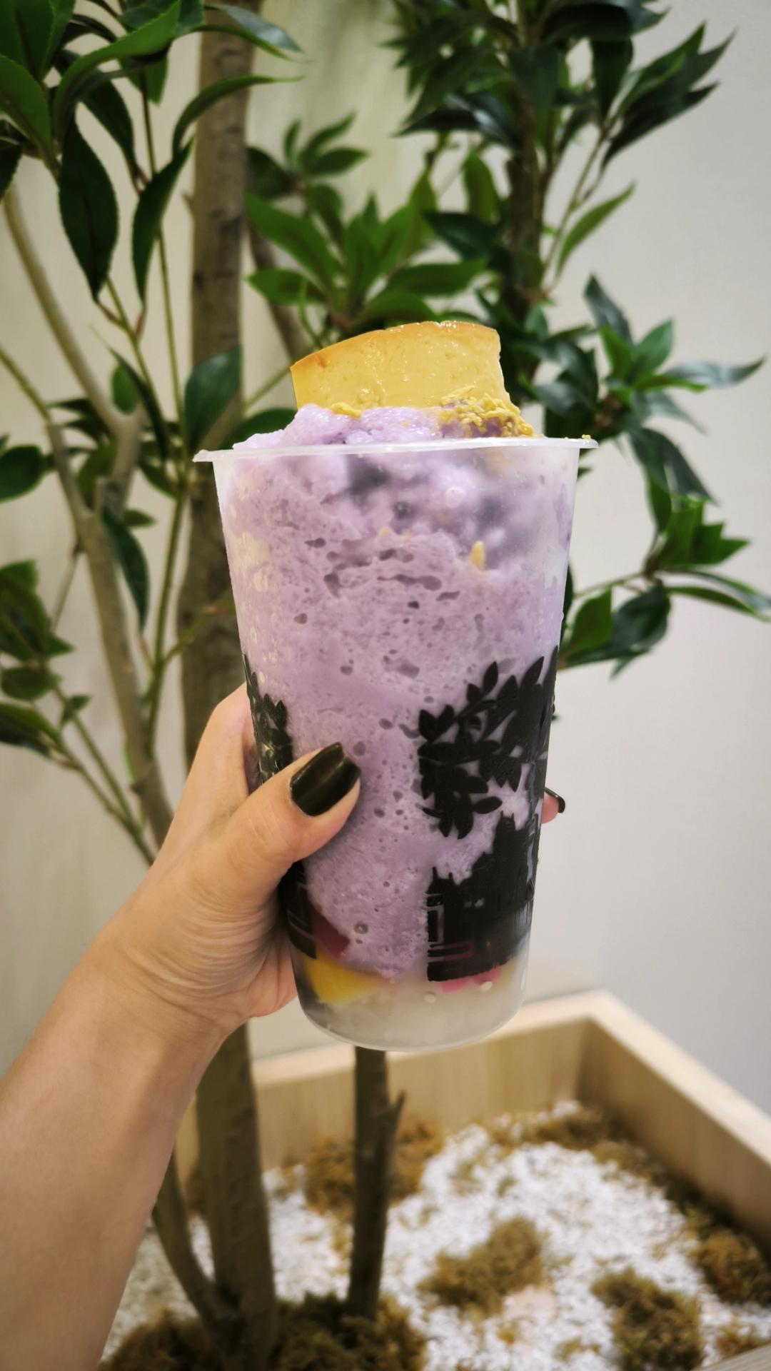 side view of cup with purple shaved ice and a lech flan on top