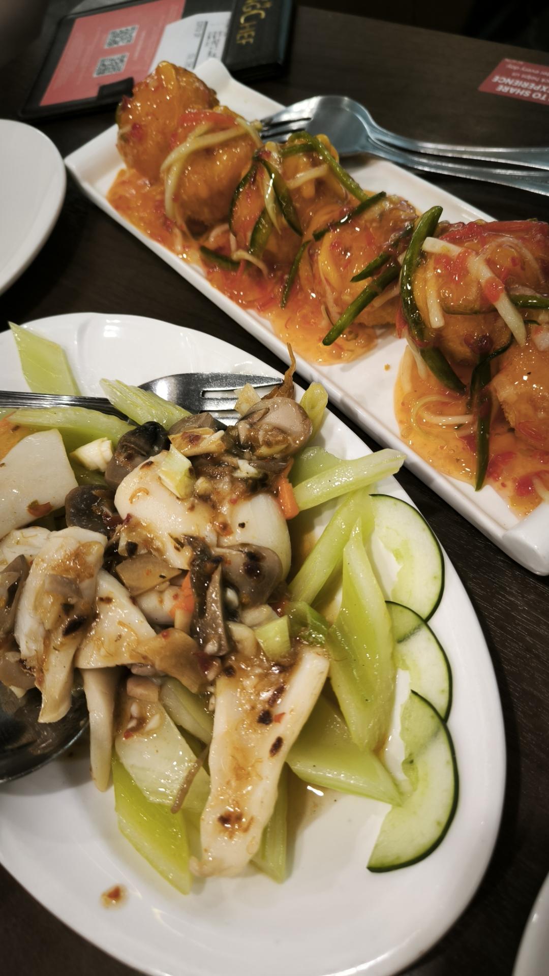 two plated dishes. squid with celery and mushroom in xo sauce. silken tofu balls in crispy breading with mango sauce and strips of bellpepper.